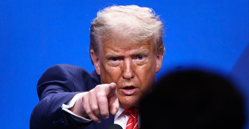 President Donald Trump in a blue suit points