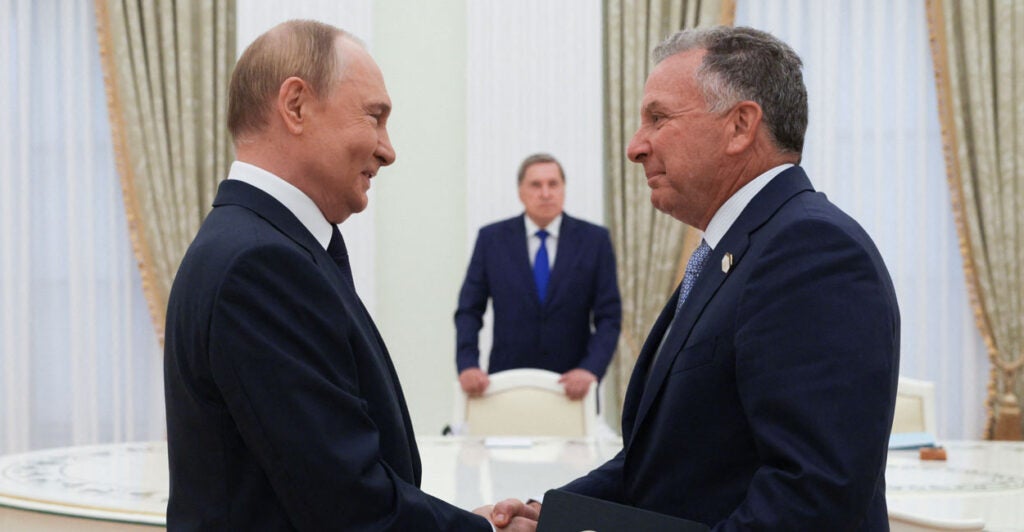 Russian President Vladimir Putin and U.S. Special Envoy for Peace Missions Steve Witkoff shake hands as they face each other.