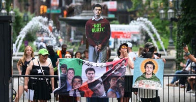Protesters holding photos of Luigi Mangione.