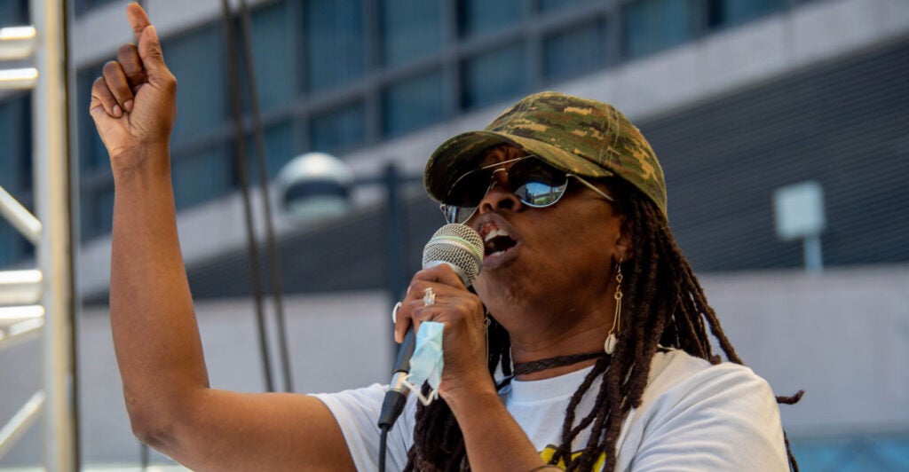 Iris Roley gestures with her finger as she holds a microphone.