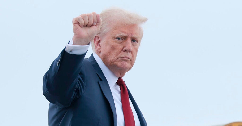 Donald Trump in a suit makes a fist