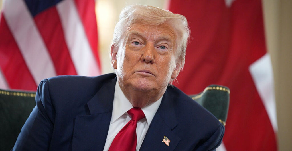 Donald Trump looks in a blue suit with a red tie