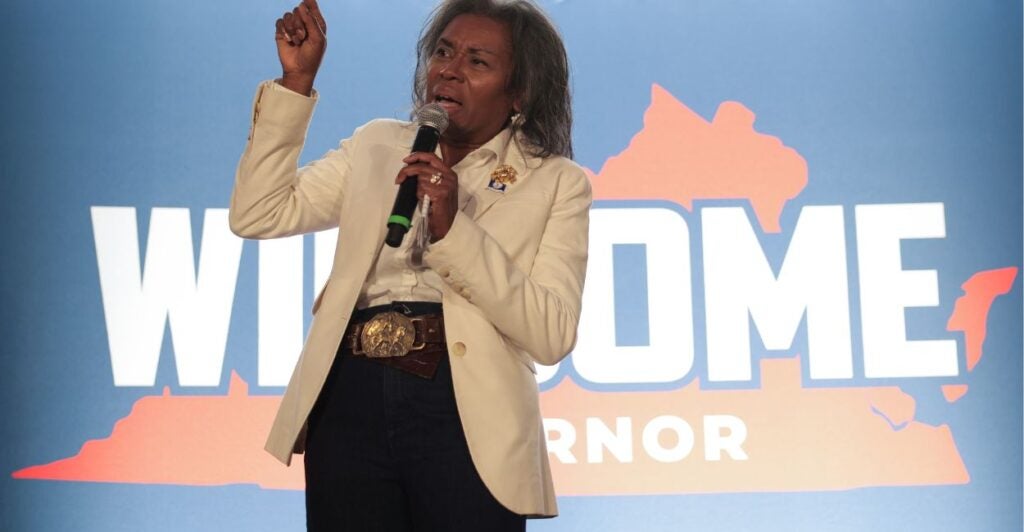 Winsome Earle-Sears stands in front of a campaign ad.