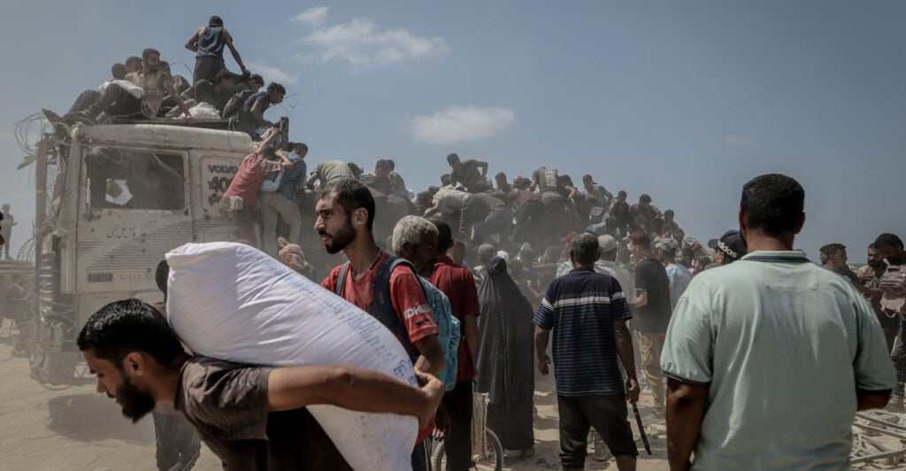 Crowds of Palestinians take food and supplies from an aid truck in northwestern Gaza.