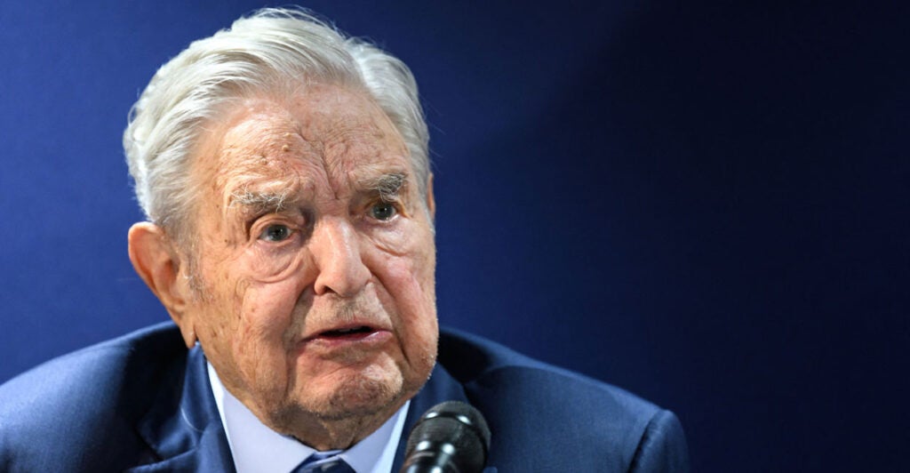 George Soros and a blue suit with a frown on his face