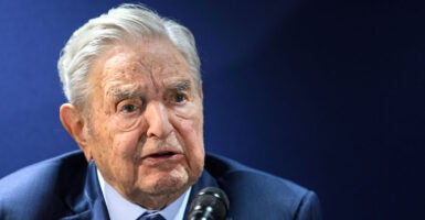 George Soros and a blue suit with a frown on his face