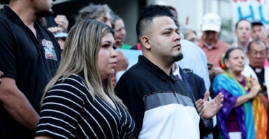 Kilmar Abrego Garcia stands next to his wife, Jennifer Vasquez Sura, while surrounded by a crowd of people.