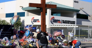 Dan Beazley and Natalia Hernandez pray at the makeshift memorial for Charlie Kirk outside of the headquarters of Turning Point USA on Tuesday in Phoenix, Arizona.