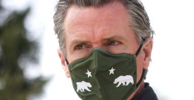 California Gov. Gavin Newsom is seen here at the height of the COVID-19 pandemic on March 10, 2021 in South Gate, Calif., wearing a mask with the state symbols of bears and stars on it.