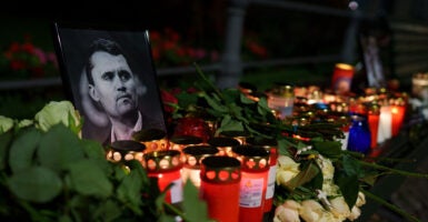 A photo of Charlie Kirk is surrounded by gifts, flowers and candles at a memorial.