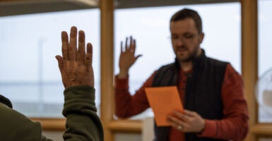 A U.S. Citizenship and Immigration Services officer leads an immigrant from Thailand in the oath of allegiance to the United States after the applicant passed his naturalization exam, in Utqiagvik, Alaska, on Aug. 9, 2023.