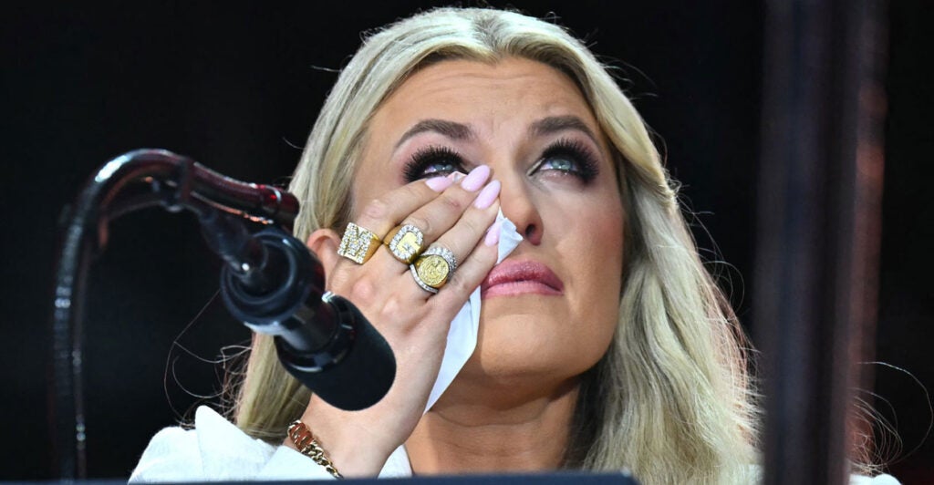 Close-up of Erika Kirk whipping away tears while delivering remarks at her husband's memorial service.