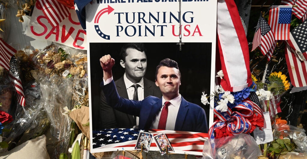 Turning Point USA display including photo with a color and black-and-white photo of Charlie Kirk.