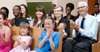 A mix of people of all races and ages happily attend a church service.