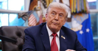 President Trump at his desk in the Oval Office, looking up.