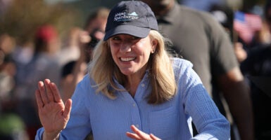 Abigail Spanberger in blue dancing with a campaign hat on.