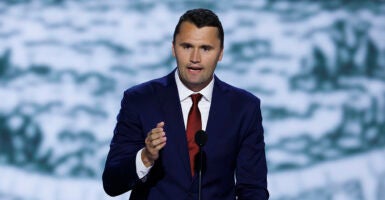 Charlie Kirk gestures in a blue suit