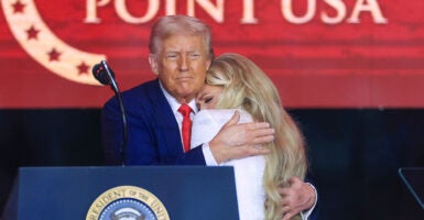 President Donald Trump embraces a tearful Erika Kirk, Charlie Kirk's widow, at his memorial service in Phoenix, Arizona.