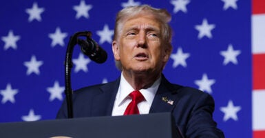 Donald Trump speaks in front of an American flag.
