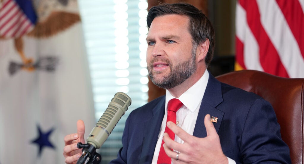 Vice President JD Vance is sitting down talking into a podcast microphone.