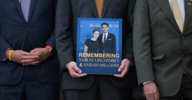 A picture of Sarah Milgrim and Yaron Lischinsky is held up at their memorial.