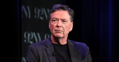 James Comey in black with a grey suit coat