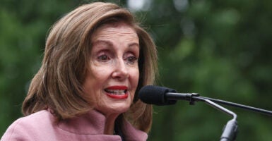 Nancy Pelosi speaking into a microphone outside