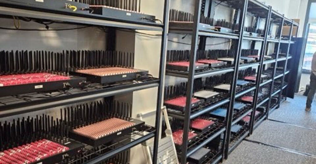 A row of metal racks containing electronic equipment for a server farm.