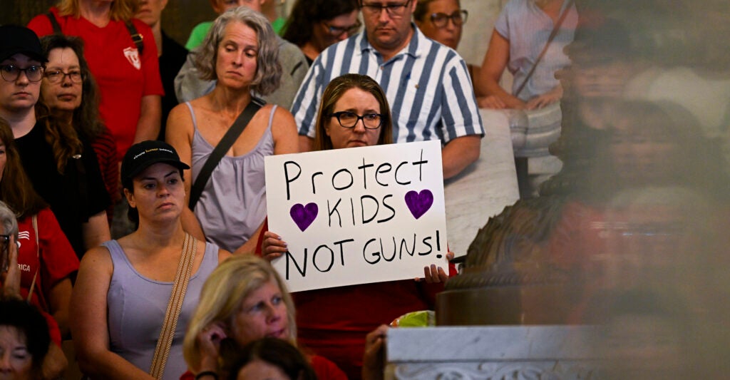 People attend a press conference with city officials and gun legislation advocates following a mass shooting at Annunciation Catholic School.