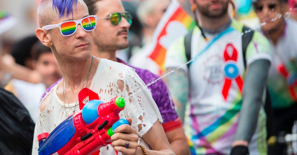 A man cools down spectators with his water gun as he marches in the Pride Parade.