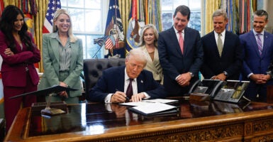 Surrounded by stakeholders, President Donald Trump on Monday signs a memo that authorizes sending members of the National Guard to Memphis, Tenn.