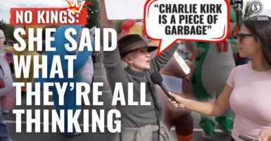 Older woman at No Kings Day in Washington D.C. holding while saying "Charlie Kirk is a piece of garbage."