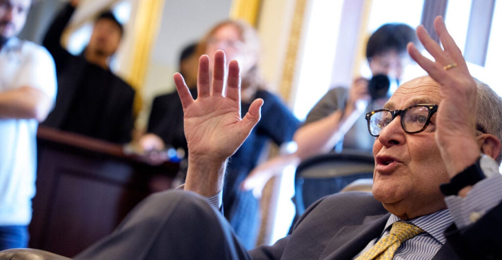 A nearly recumbent Senate Minority Leader Chuck Schumer, D-N.Y., speaks with reporters at the Capitol on Wednesday.