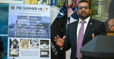 At a press conference with President Donald Trump at the White House on Wednesday, FBI Director Kash Patel speaks next to a poster detailing the anti-crime accomplishments of the bureau's Operation Summer Heat.