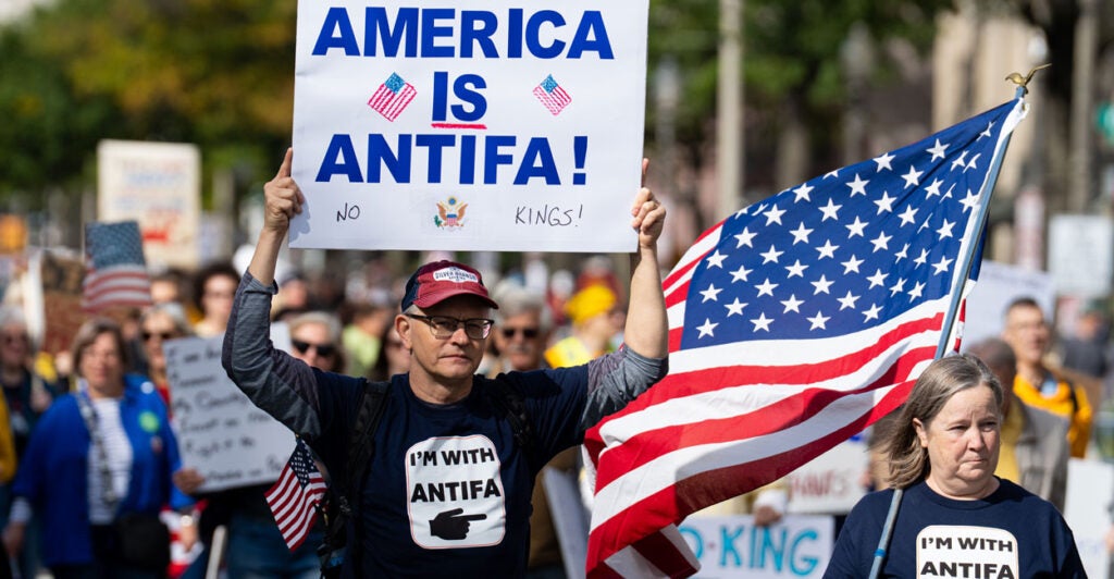 Leftist protesters march down Pennsylvania Avenue Northwest in Washington, D.C., on Saturday in an anti-Trump "No Kings" rally. Two of the protesters are wearing "I'm with Antifa" shirts and one of them is carrying a sign that reads "America is Antifa."