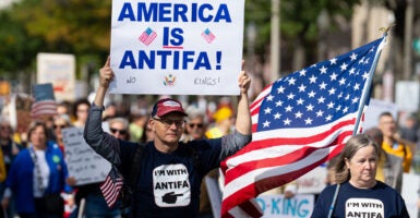Leftist protesters march down Pennsylvania Avenue Northwest in Washington, D.C., on Saturday in an anti-Trump "No Kings" rally. Two of the protesters are wearing "I'm with Antifa" shirts and one of them is carrying a sign that reads "America is Antifa."