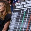 Rep. Lisa McClain, R-Mich., attends a GOP leadership news conference at the Capitol on Oct. 17 on the federal government shutdown. A chart beside her shows a comparison of votes on the issue between Republicans and Democrats.