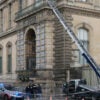 French police officers stand next to a furniture elevator used by robbers to enter the Louvre Museum.