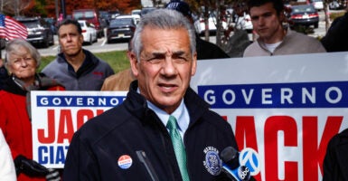 New Jersey Republican gubernatorial candidate Jack Ciattarelli speaks with reporters Friday in Bridgewater, New Jersey, with supporters standing behind him holding campaign signs.