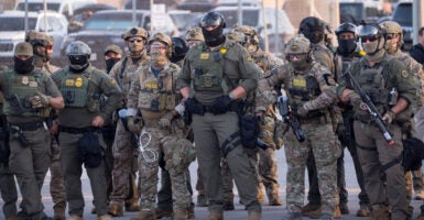 U.S. Immigration and Customs Enforcement agents, Department of Homeland Security personnel, and Border Patrol Commander Gregory Bovino stand together amid a protest outside the ICE processing facility in Broadview, Illinois, on Sept. 27.