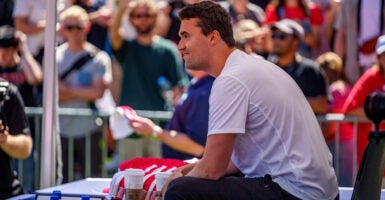Side view of Charlie Kirk in a white shirt leaning forward during the rally where he was killed.