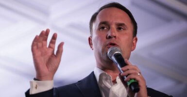 Virginia Attorney General Jason Miyares with hand raised speaks during a campaign event.