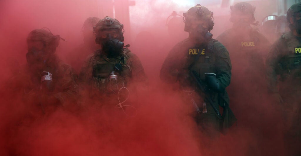 Federal agents amid a haze of pink smoke.