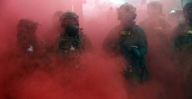 Federal agents amid a haze of pink smoke.