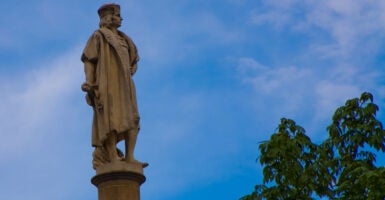 Statue of Christopher Columbs against a blue sky.