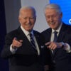 Presidents Joe Biden and Bill Clinton stand side-by-side, smiling and pointing.