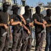 Masked men with weapons are seen in Gaza on Monday.