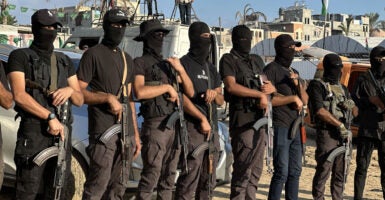 Masked men with weapons are seen in Gaza on Monday.