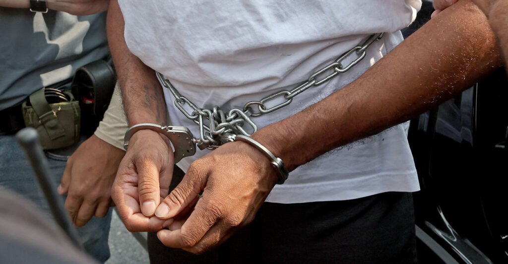 Immigration officials make arrests in Boston on Sept. 6, with one detainee being handcuffed.