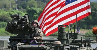 A U.S. soldier sits atop a Stryker infantry carrier vehicle crossing a river over a floating bridge during a joint U.S.-South Korea river-crossing drill as part of annual military exercises in Yeoju, South Korea, on Aug. 27.